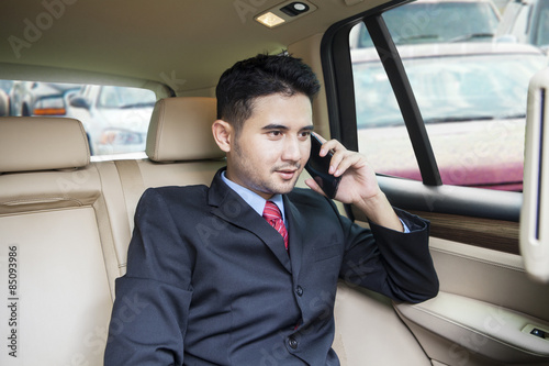 Busy entrepreneur talking on the phone in car © Creativa Images