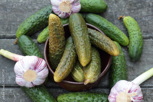 Closeup of some pickled and fresh cucumbers.