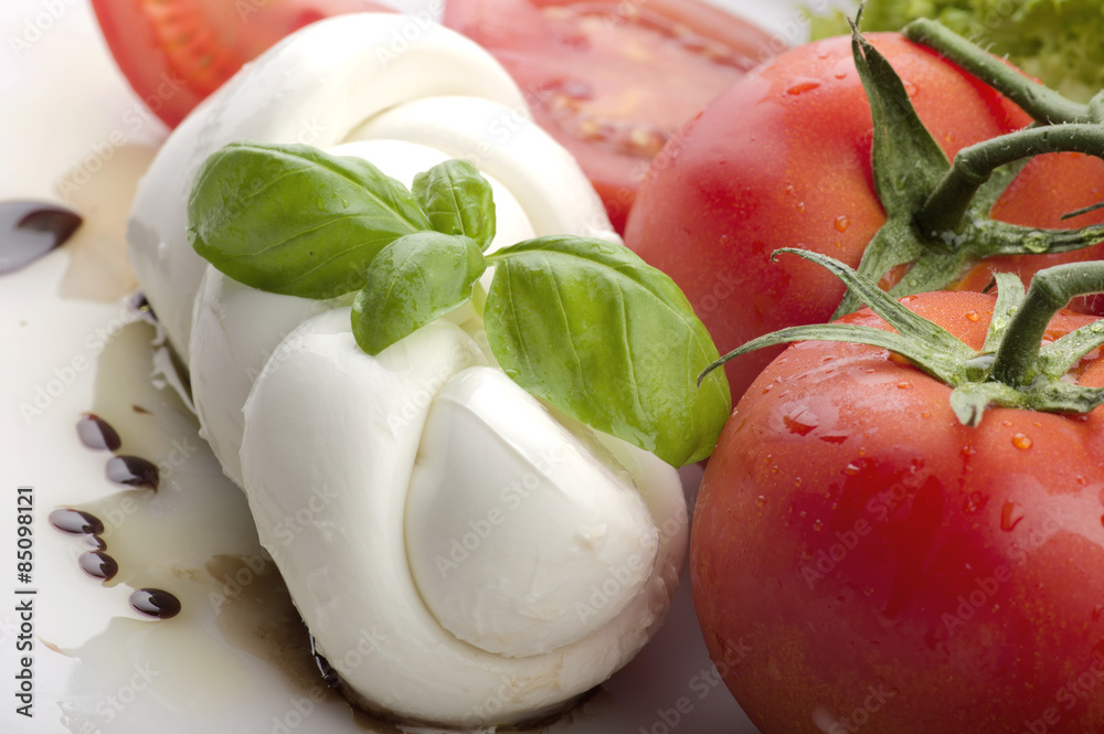 Mozzarella tomatoes and fresh salad on the white Mozzarella tomatoes and fresh salad on the white