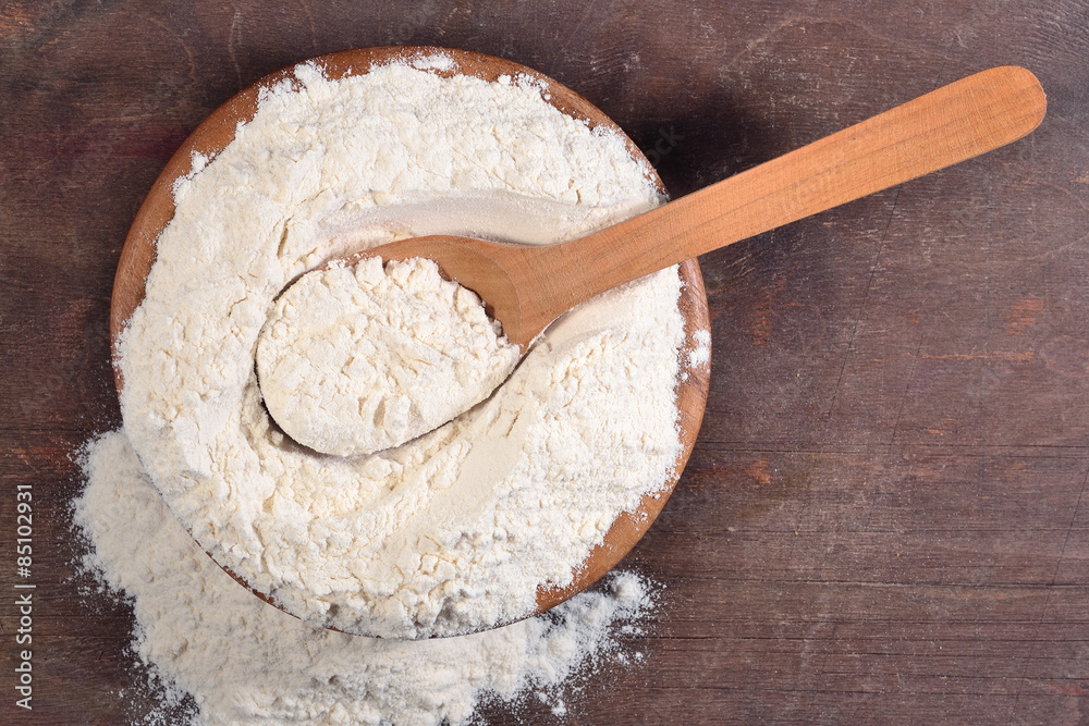 White flour in a wooden bowl White flour in a wooden bowl