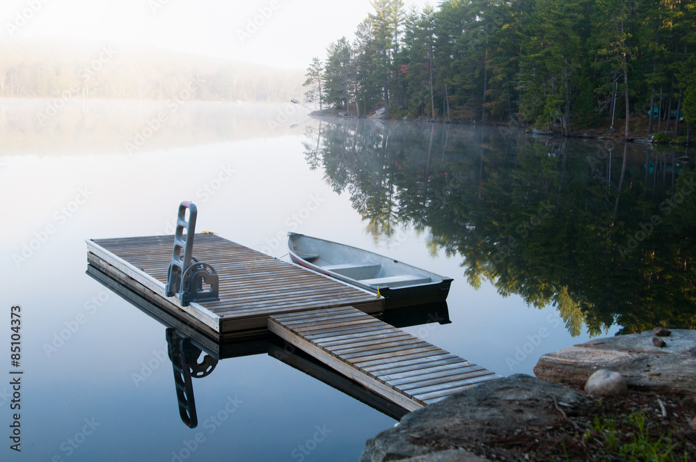 Dock with a fishing boat in the early morning mist Dock with a fishing boat in the early morning mist