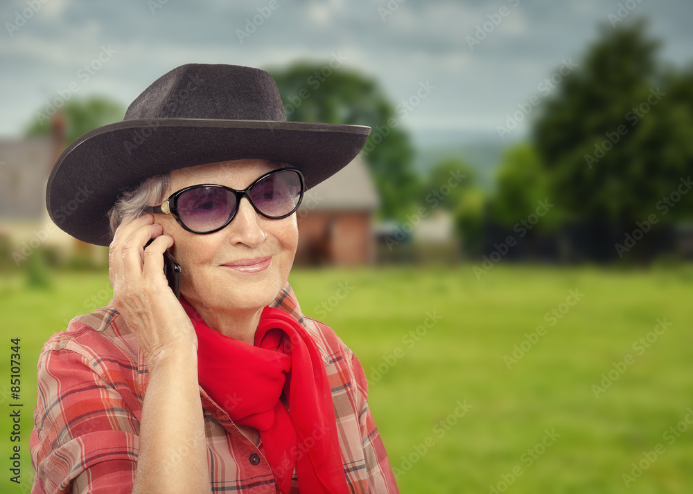 Old cowgirl talking on smartphone