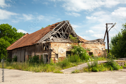 Photography Ruined brick/wooden house - destroyed roof, vegetation.