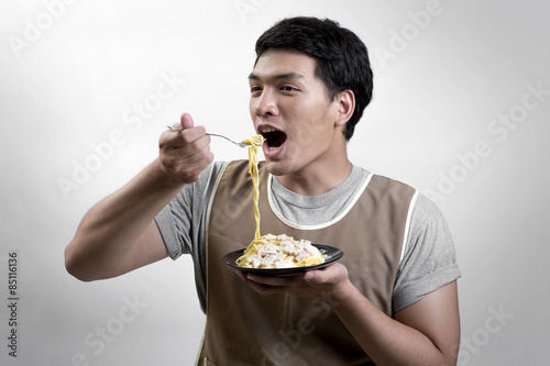 Asian man eatting spaghetti carbonara