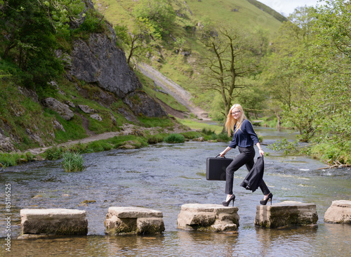 young business woman stepping stones to success metaphor