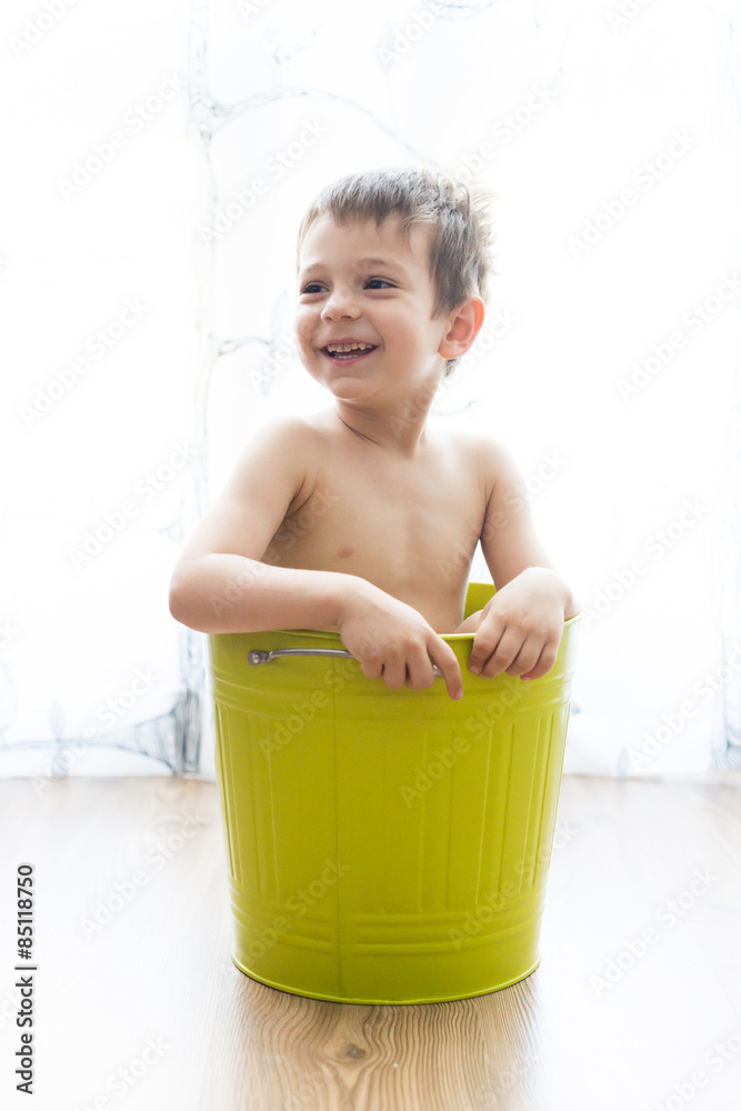 kid bathing in a green bucket