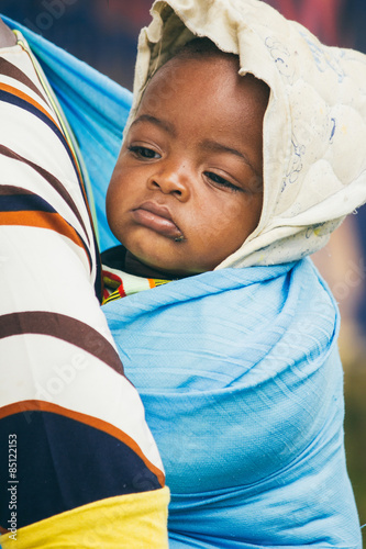 African baby carried on the back of his mother