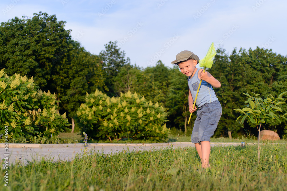 Cute funny little boy running to catch butterflies