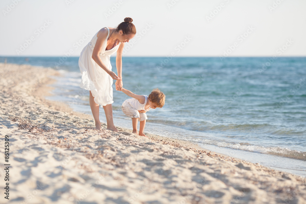Mother and son collecting seashells on the beach Mother and son collecting seashells on the beach