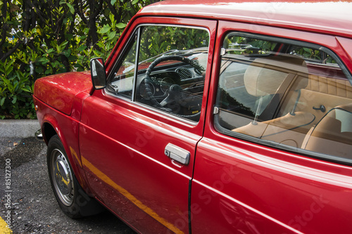 red oldtimer fiat with leather seats partial view chromed Roter Fiat mit Ledersitzen, geparkter alter Fiat 128 in perfektem Zustand, ohne Lackschaeden, perfektly Fiat Crysler 128, red, biutyful, photo