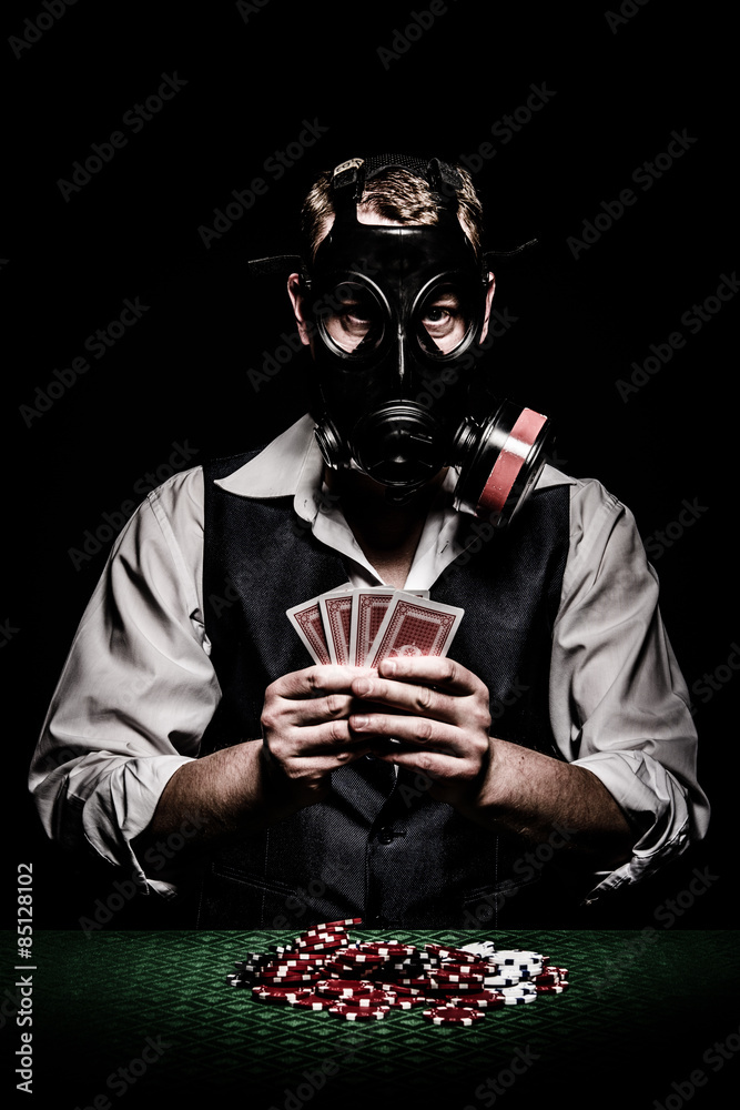 Poker player with a gas mask on his head StockFoto Adobe Stock