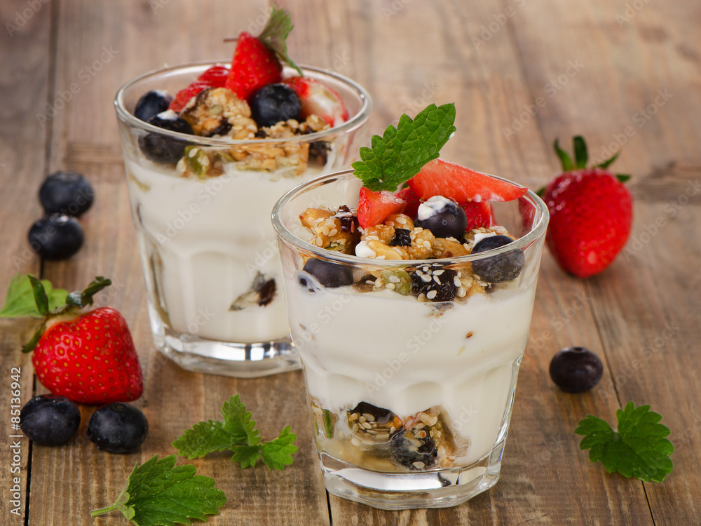 Yogurt with Granola and fresh berries on a wooden background. Yogurt with Granola and fresh berries on a wooden background.