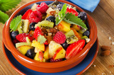 Fresh healthy fruit salad on wooden background.