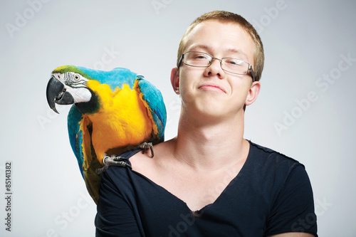 
happy young man with a parrot