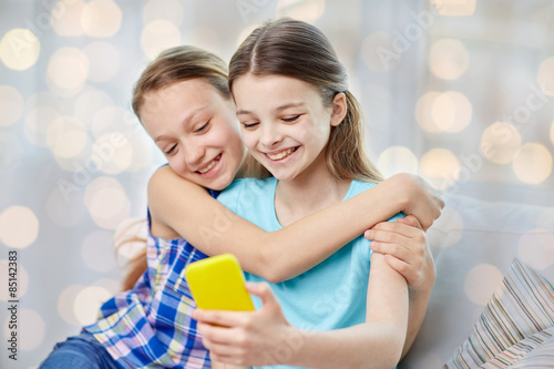 happy girls with smartphone taking selfie at home