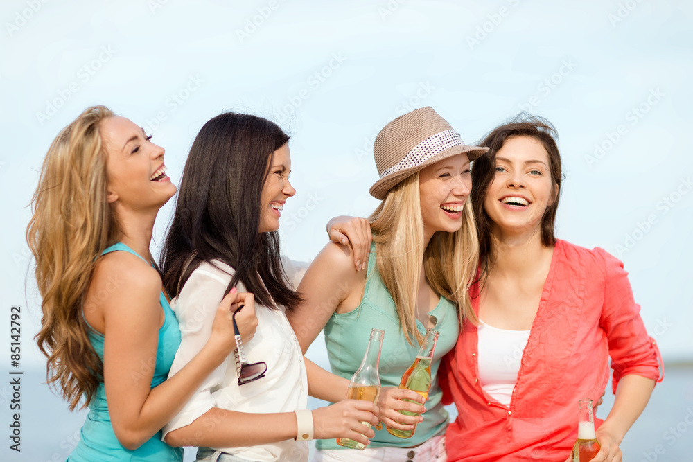smiling girls with drinks on the beach smiling girls with drinks on the beach