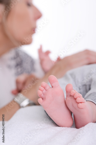 mature blonde woman playing and taking care of her new born baby boy