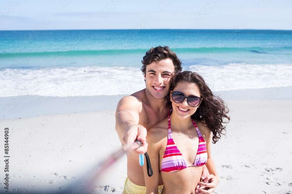 Happy couple taking selfie with selfie stick Happy couple taking selfie with selfie stick