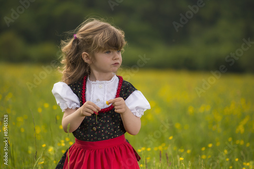 Obraz na płótnie Bambina con abito tradizionale nel campo di fiori w salonie