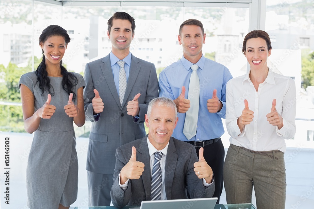 Smiling business team standing thumbs up Smiling business team standing thumbs up