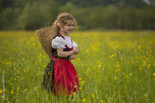 Obraz na płótnie Bambina nel campo di fiori con gerla w salonie