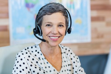 Smiling travel agent sitting at her desk