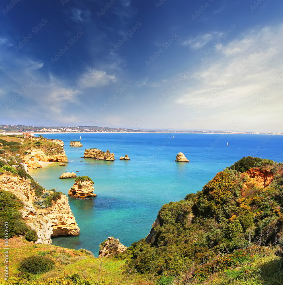 Rocky beach at sunset, Lagos, Portugal. Counter light. Travel and business background