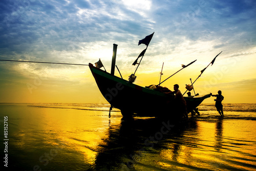 Fototapet Fishermen fishing in the sea at sunrise in Namdinh, Vietnam.