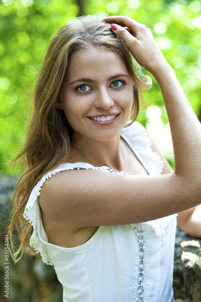 Young beautiful woman in green dress posing outdoors in sunny we Young beautiful woman in green dress posing outdoors in sunny we