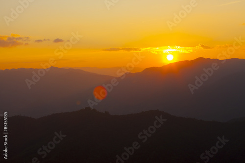 dramatic sky sun set over mountain with orange dramatic sky with lensflare