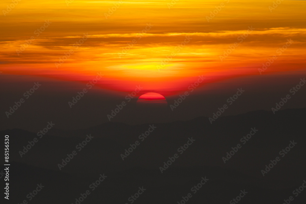 Naklejka premium dramatic sky sun set over mountain with orange dramatic sky with lensflare