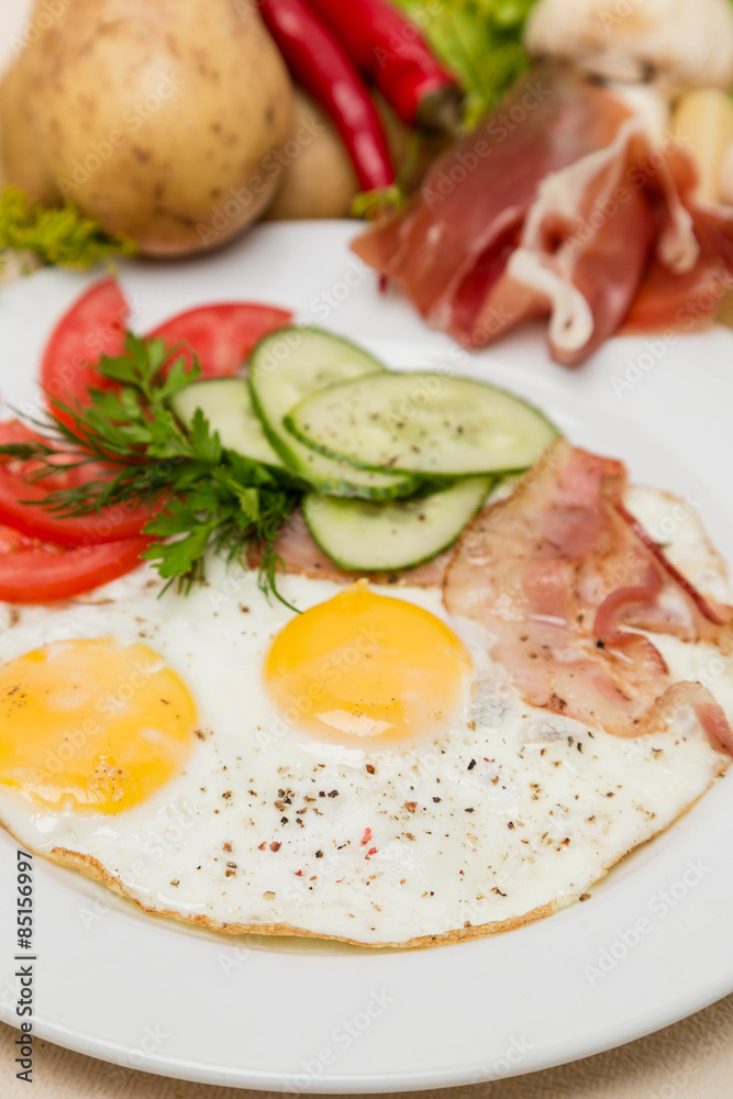 bacon and eggs with garnish on white plate bacon and eggs with garnish on white plate