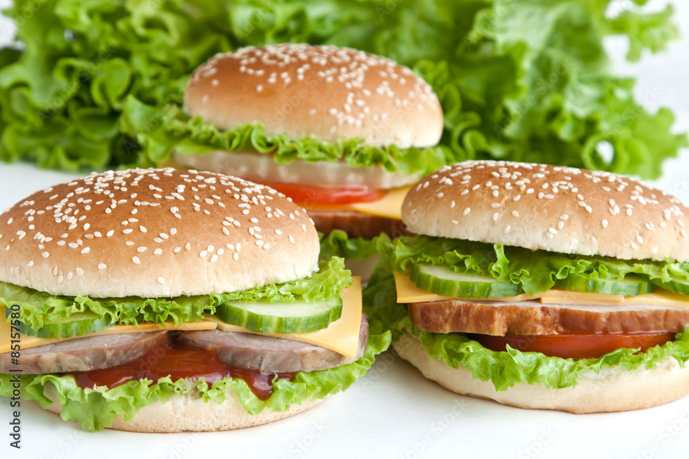 three burger with meat and vegetables