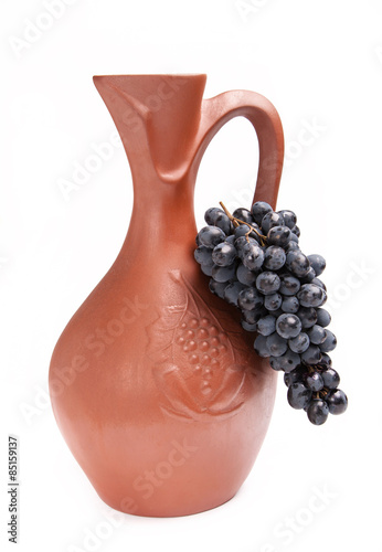 traditional clay jug for wine with bunch grapes
