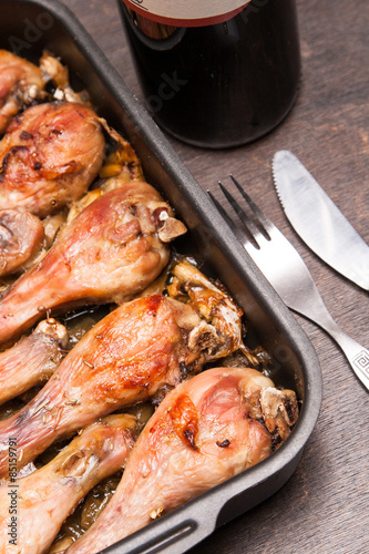 baked chicken legs in tray on black wooden