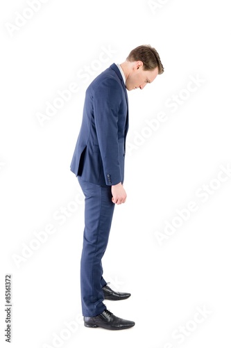 Defeated businessman looking at his shoes 