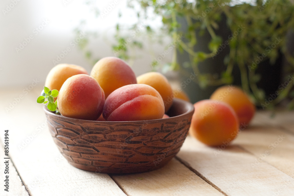 apricots in ceramic cup on wooden table. selective focus