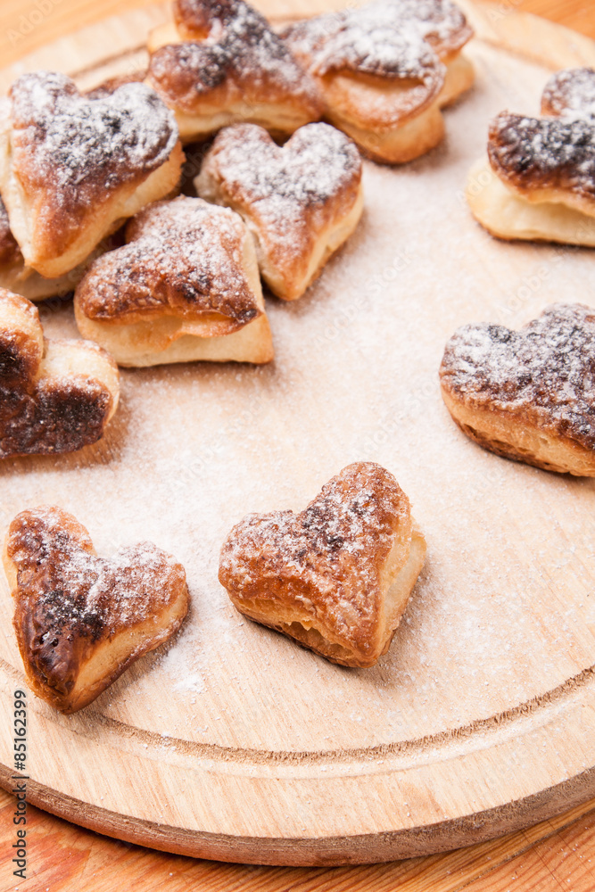 bakery hearts from split pastry with sugar powder on wooden