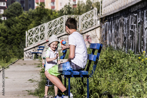 child and teenager playing in the street Water Gun