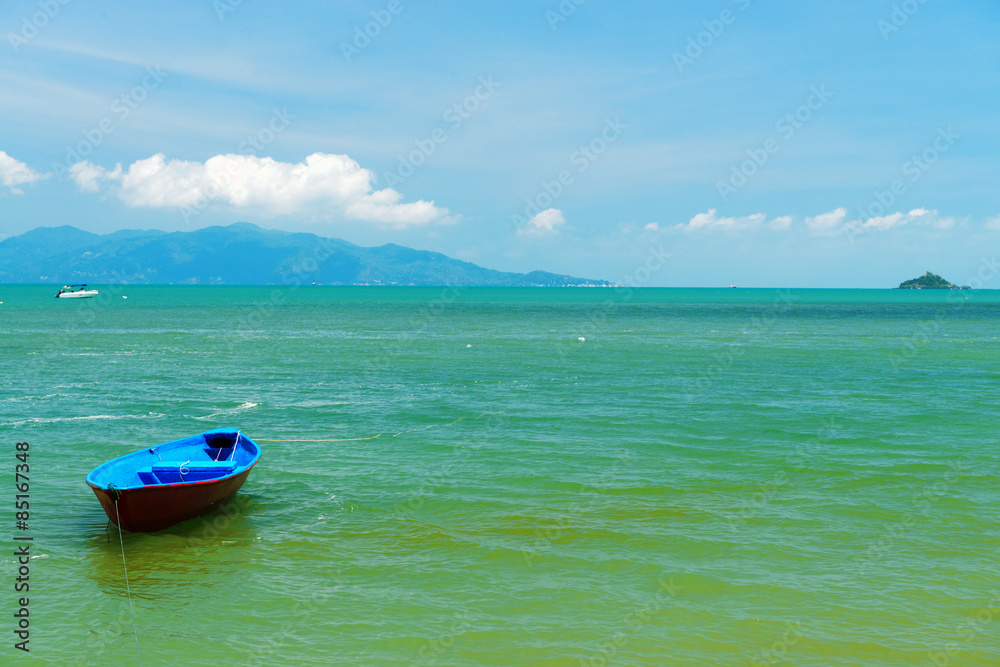 A small wooden boat moored on a beach in Thailand