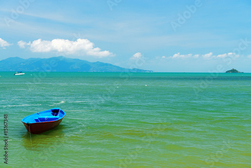 A small wooden boat moored on a beach in Thailand
