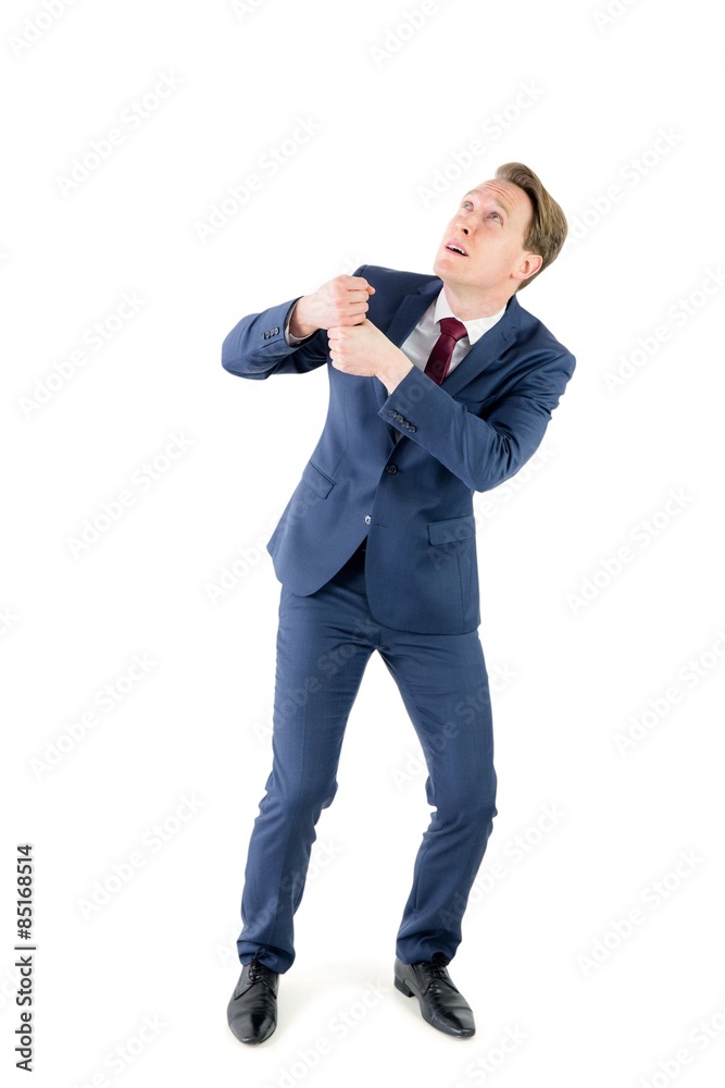 An anxious businessman pulling something An anxious businessman pulling something