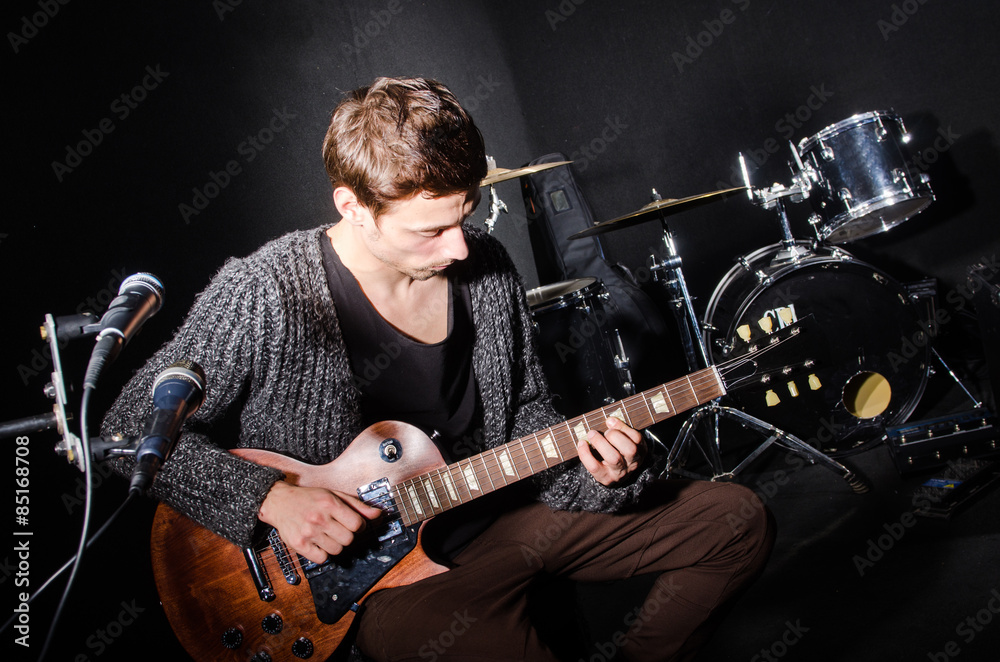 Fototapeta premium Man playing guitar in dark room