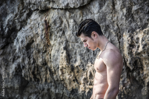 Young shirtless athletic man standing in water by ocean shore © theartofphoto