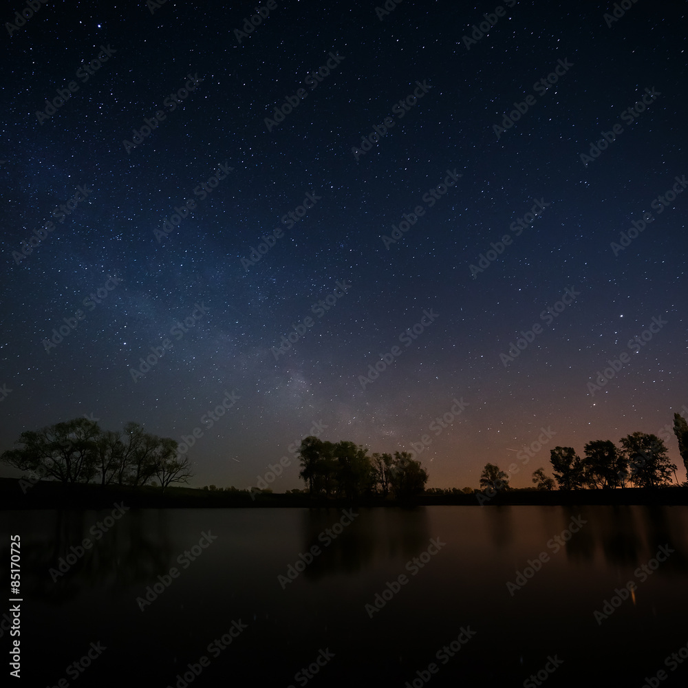 Smooth surface of forest lake on a background of the night sky Smooth surface of forest lake on a background of the night sky