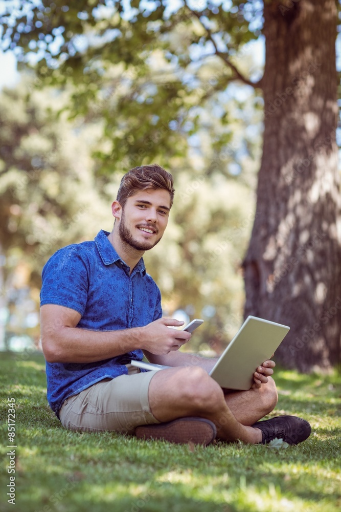 hipster using laptop and phone in the park hipster using laptop and phone in the park