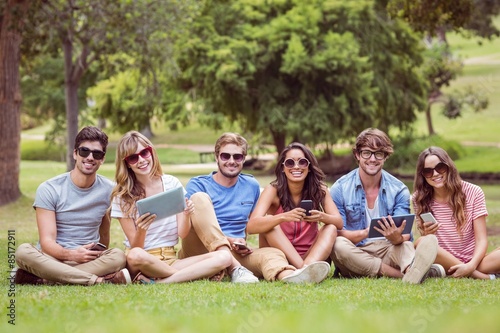 Happy friends in the park looking at tablet © WavebreakmediaMicro
