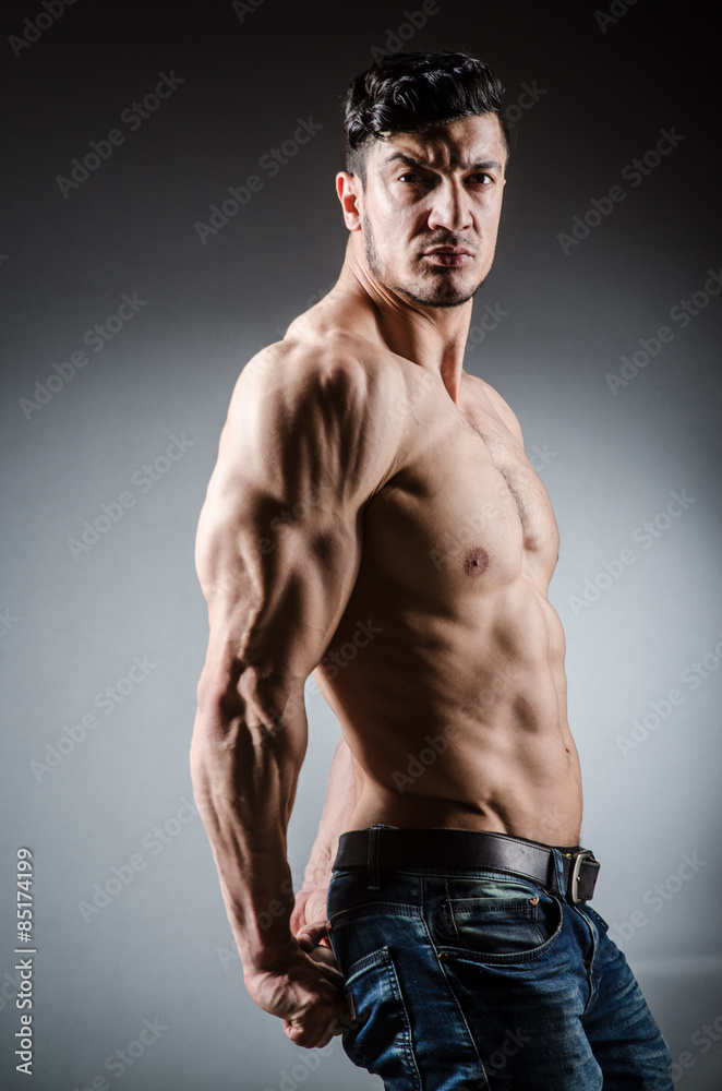 Obraz premium Muscular man posing in dark studio