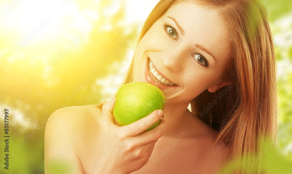 beautiful young woman eating green apple in the summer on the na beautiful young woman eating green apple in the summer on the na