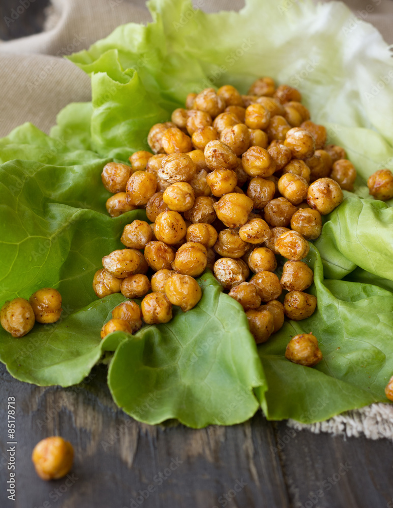 Lettuce with spicy roasted chickpeas on a wooden surface